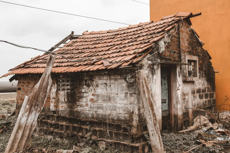 an old house with roof is leaning to the side