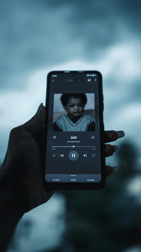 a hand holding up an iphone showing a person on a video chat