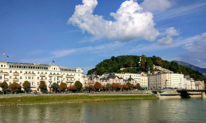 a river is running beside large buildings with a blue sky