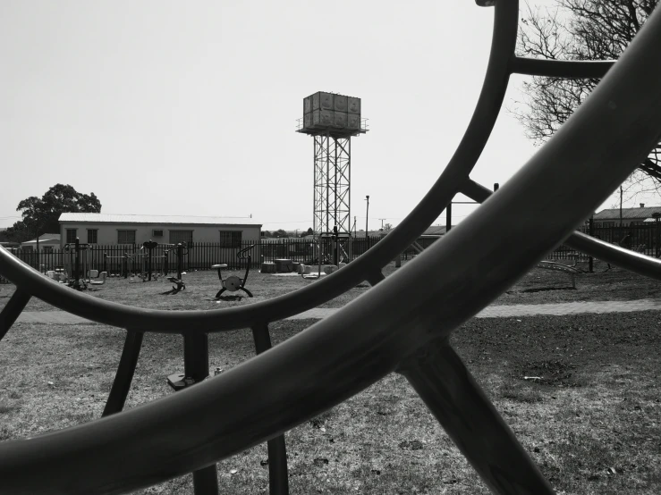 a playground with metal rings and a water tower in the background