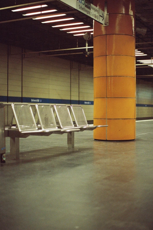 an airport with some benches, and a stop sign in the middle