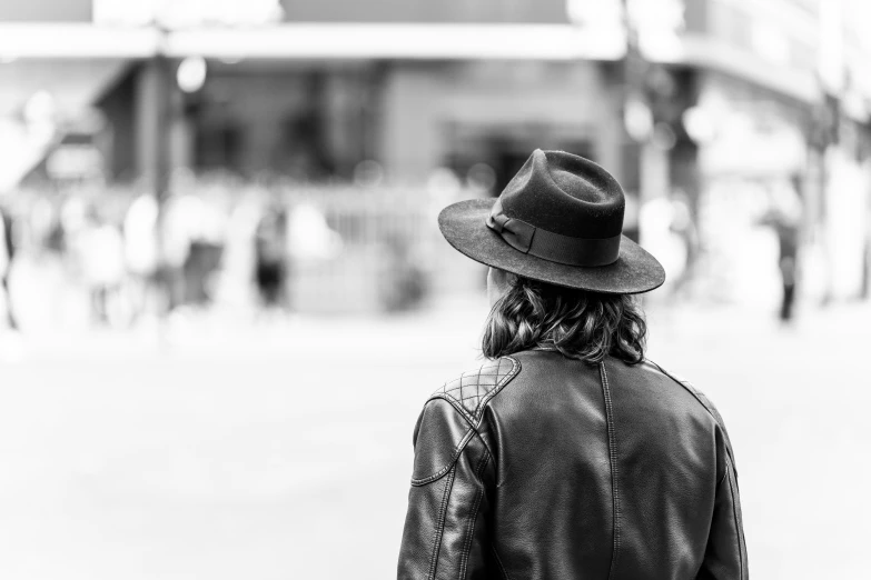 a person with a hat and coat walking on a street