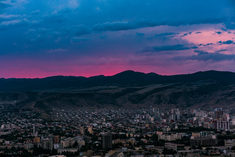 a large building near mountains and a city