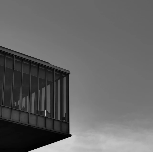 the airplane is flying over a building with no clouds