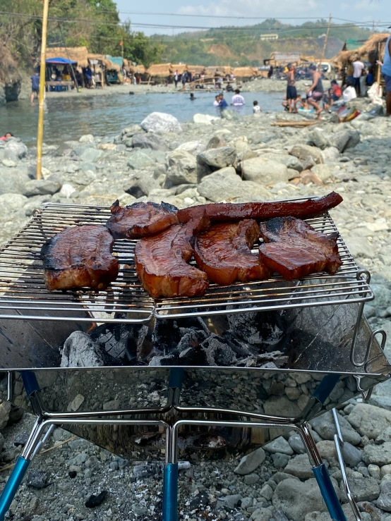 the meat is grilling on the stone bbq