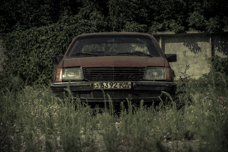 a dirty truck parked in a field surrounded by trees