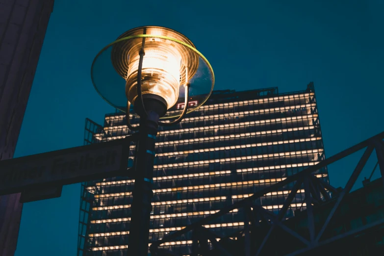 a street light sitting in front of a tall building