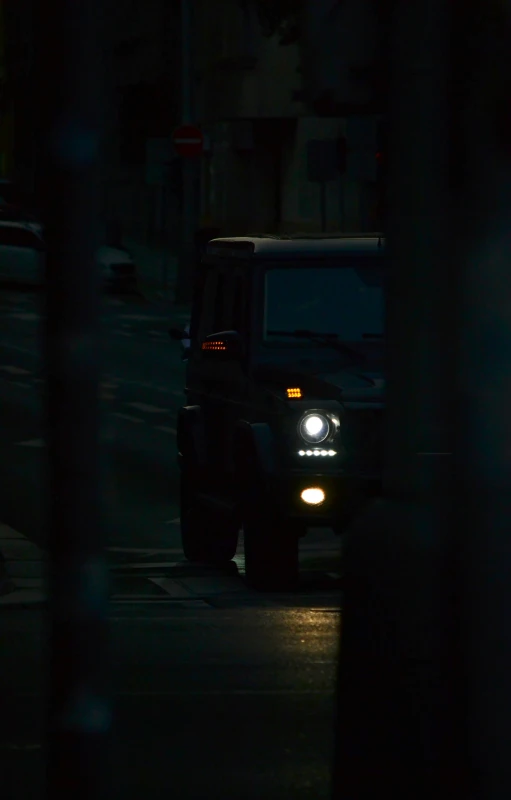 the jeeps are driving along the street at night