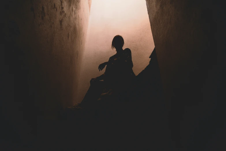 a person sitting in the dark alone, looking up