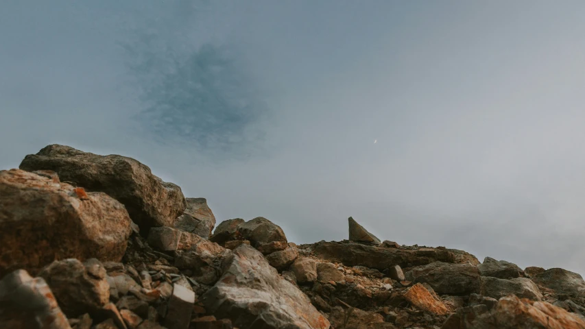 a person walks between large boulders on a sunny day