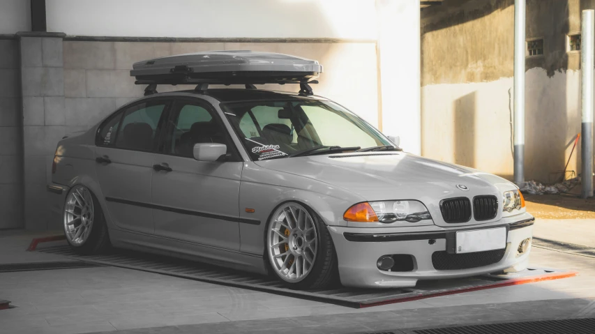 the grey car has an elevated roof rack attached