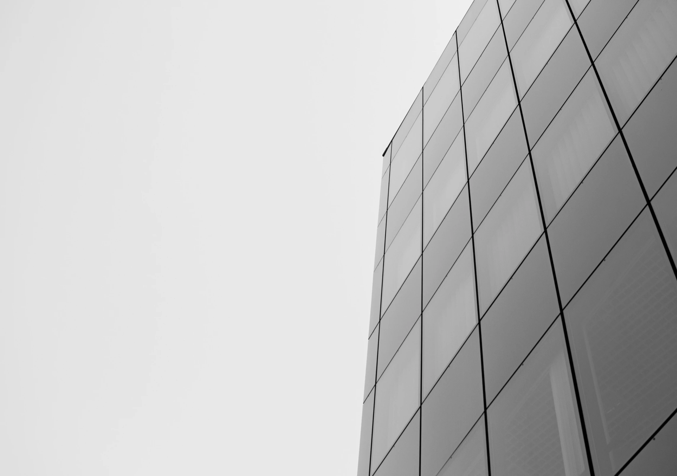 an airplane flying over the side of a tall building