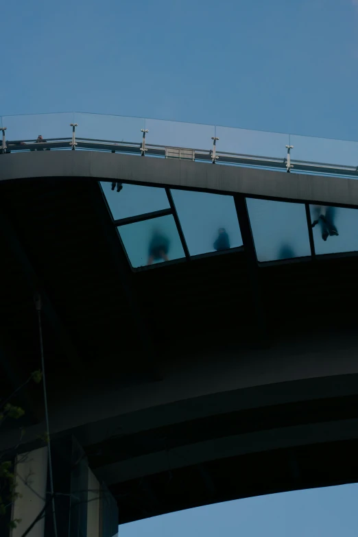 people are standing on the bridge railing