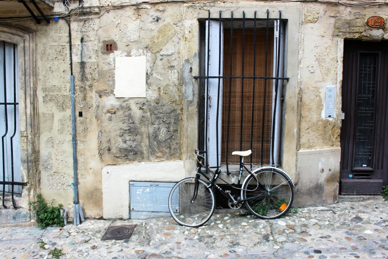 the bike is leaning against the old stone wall
