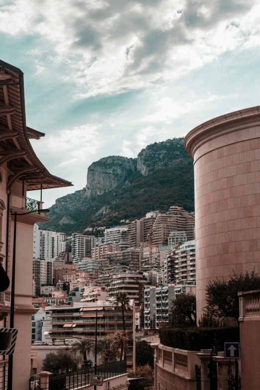 a city with buildings, a clock tower and mountains