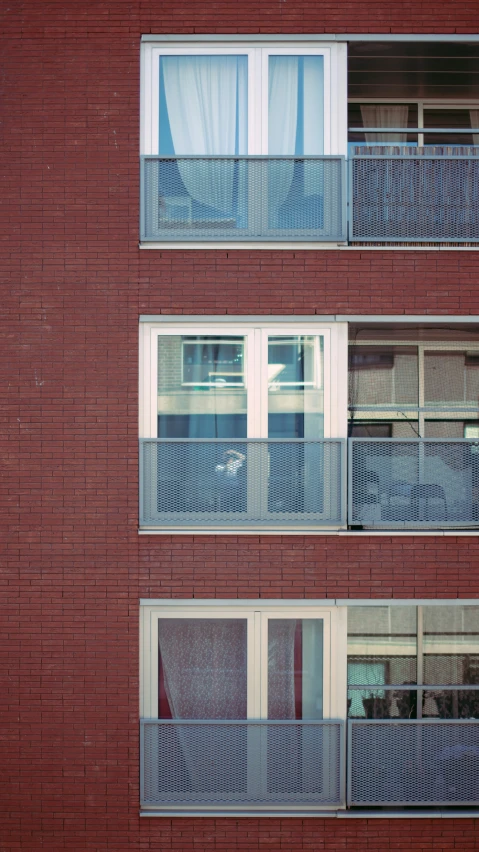 the red brick building has several windows with bars