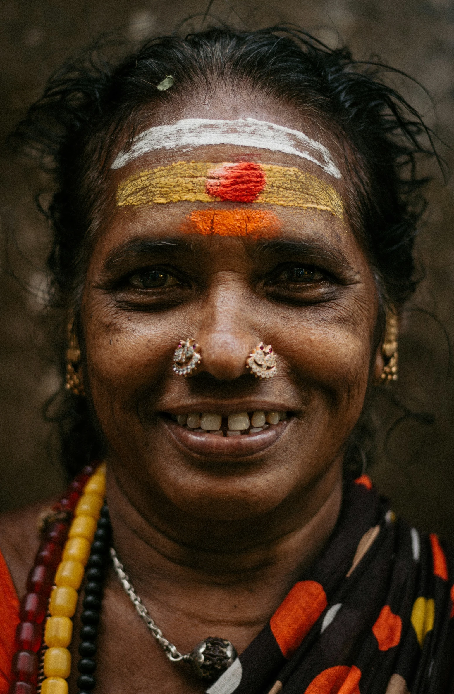 an indian woman with painted face and colorful accessories