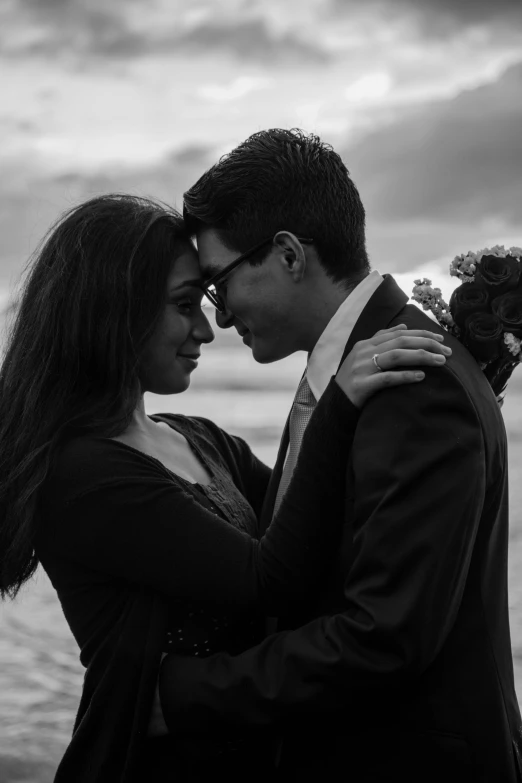 black and white pograph of couple emcing on shore