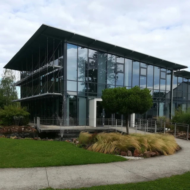 two glass buildings sit on a grassy area