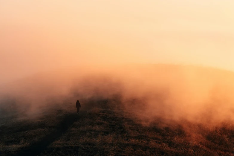 the person is standing on a foggy hill above the ground