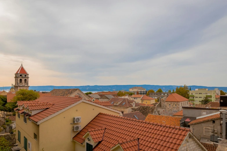 an overview of buildings in a town with a large body of water visible behind them