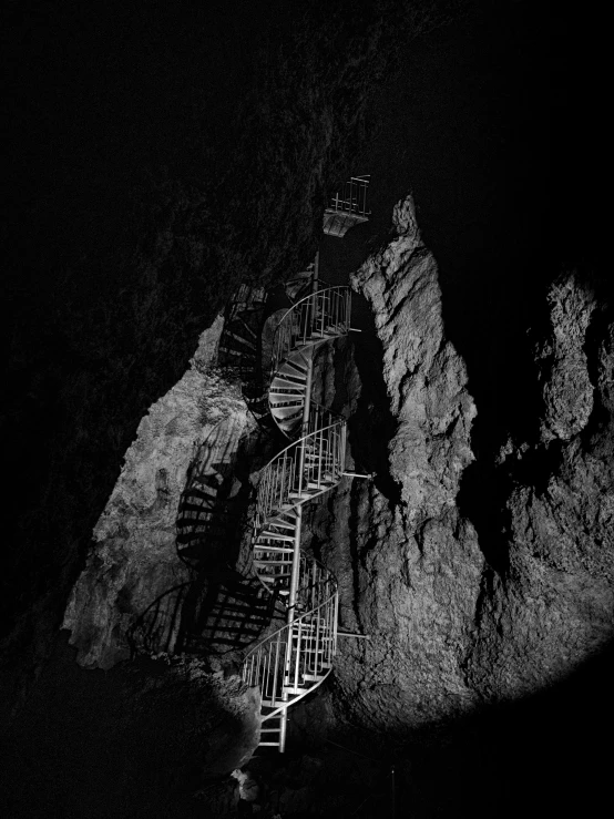 black and white image of a stair case at night