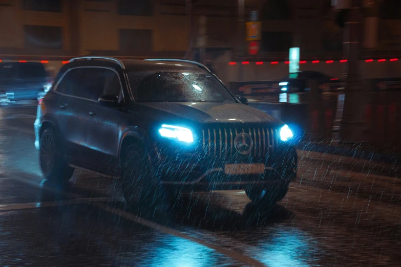 jeep driving through heavy rain in the night with headlights on