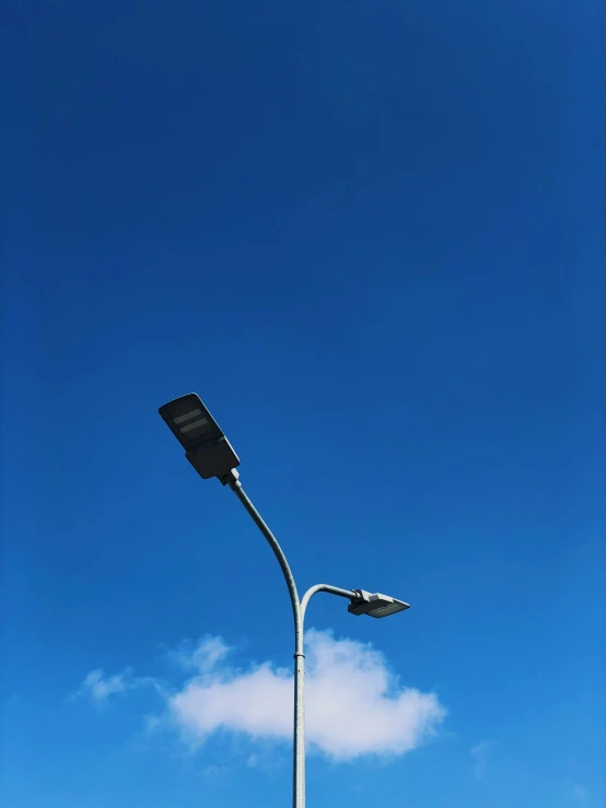 the side of a street lamp post with an overhead lamppost