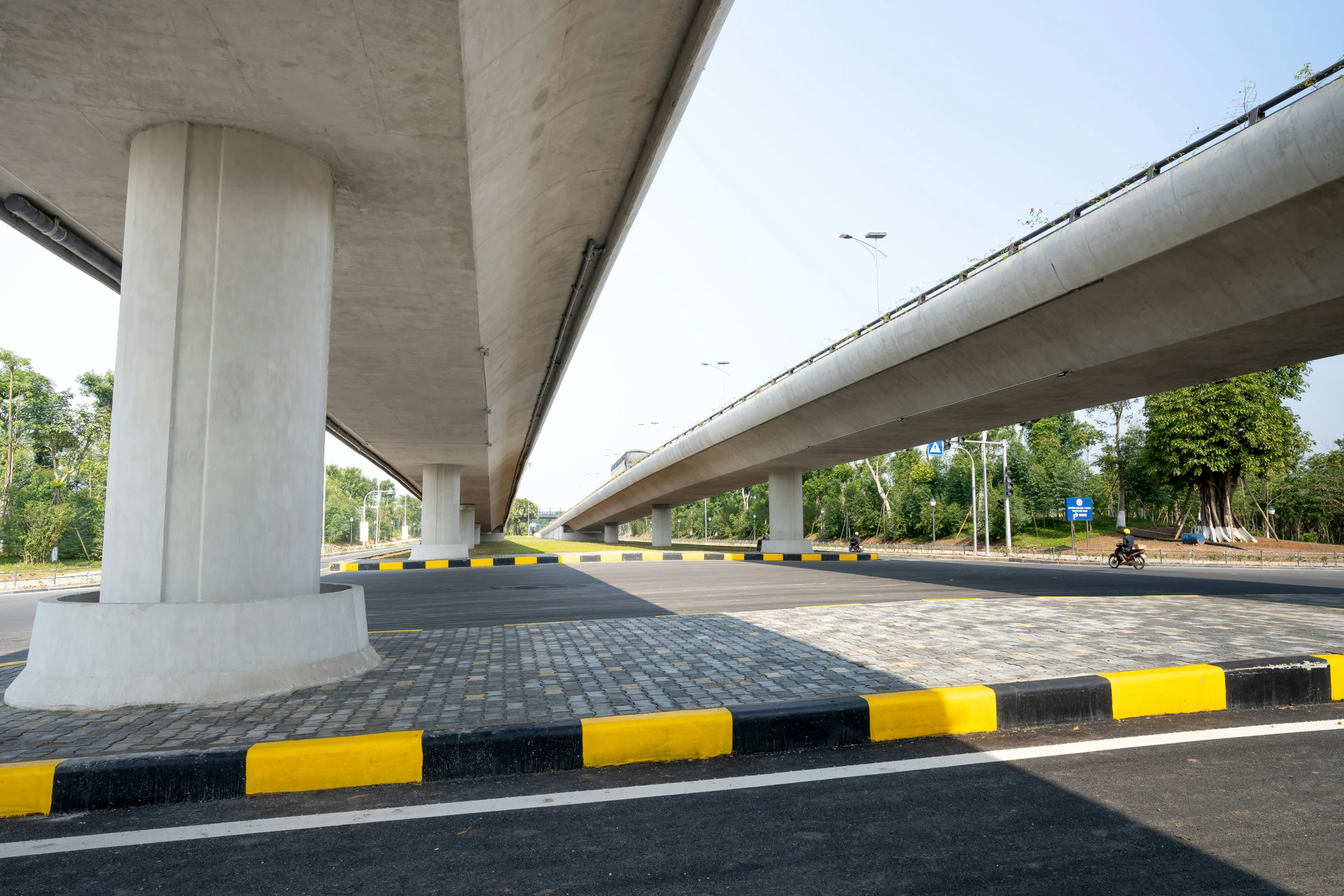 road with two yellow and white pillars leading to highway