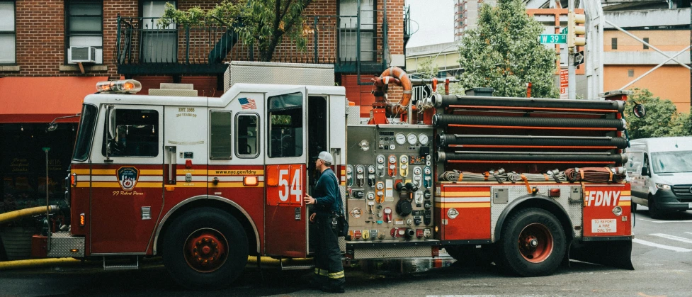 firetruck parked by fire hydrant in city setting