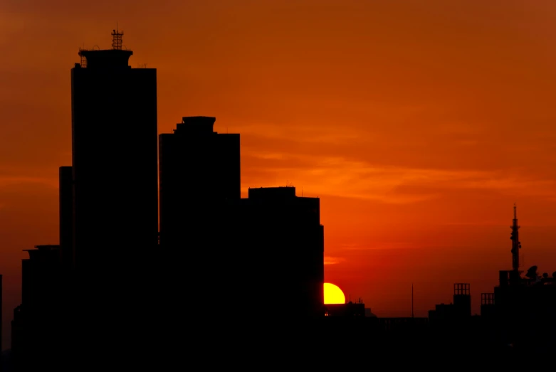 sunset with some buildings with sun in the sky