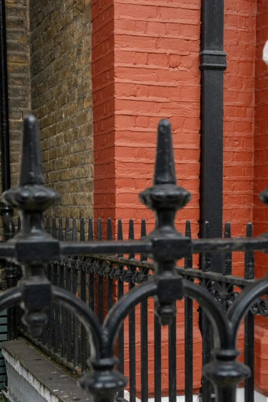 an old red brick building and a wrought iron fence