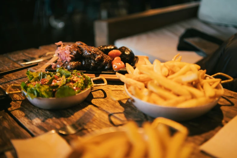 a plate of fries and some meat with a salad on the side