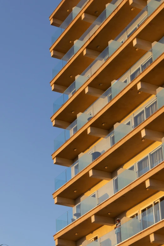 an orange building with balconies and the sky in the background
