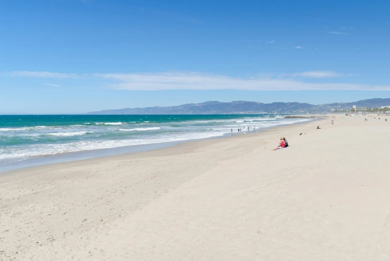 a view of a sandy beach with a mountain in the background