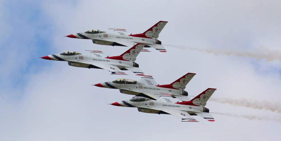 four jets are flying in the sky on a clear day