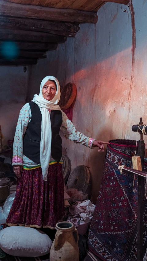 woman in a colorful skirt standing near carpets and rugs