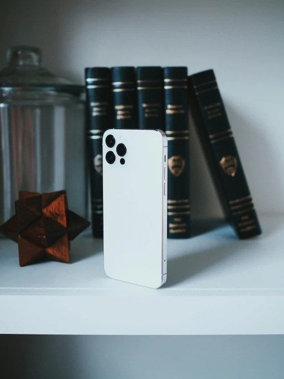 a close up of a cell phone near books