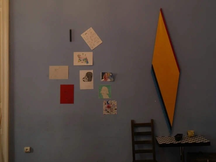 a small black chair is in front of a table with memos on the wall