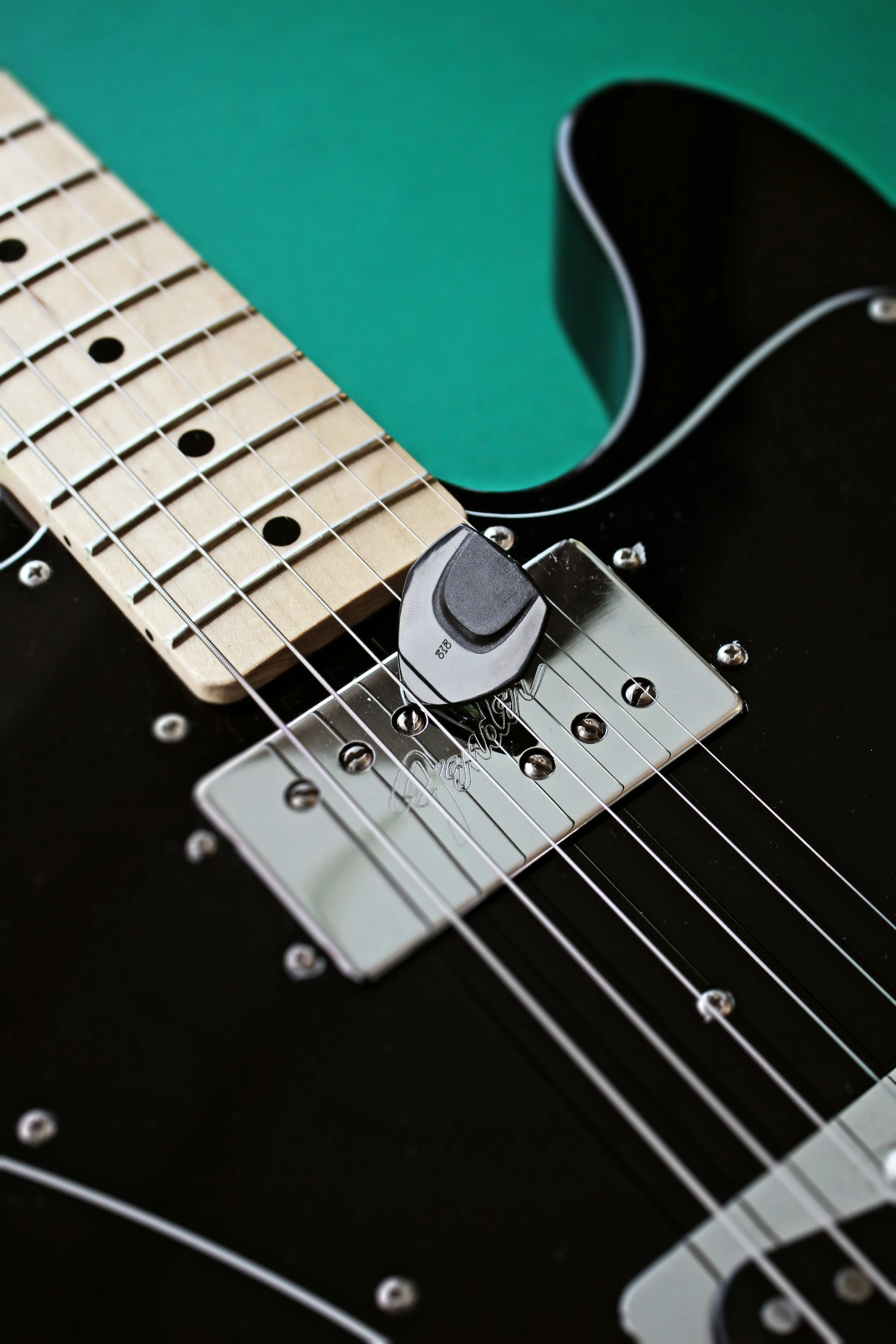 a close up view of the body and strings on a black guitar