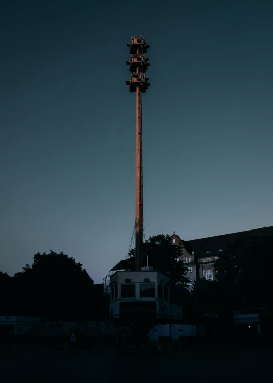 a clock on a pole sitting in the middle of a parking lot