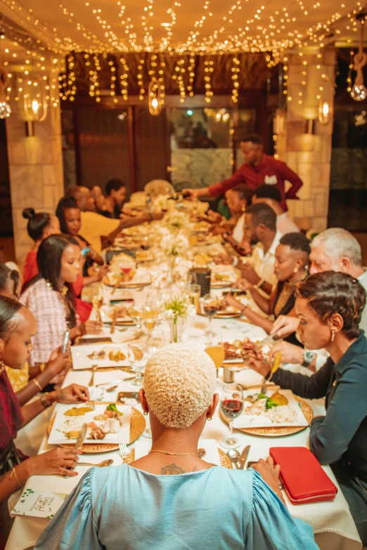 a very large long dining table with many people eating together