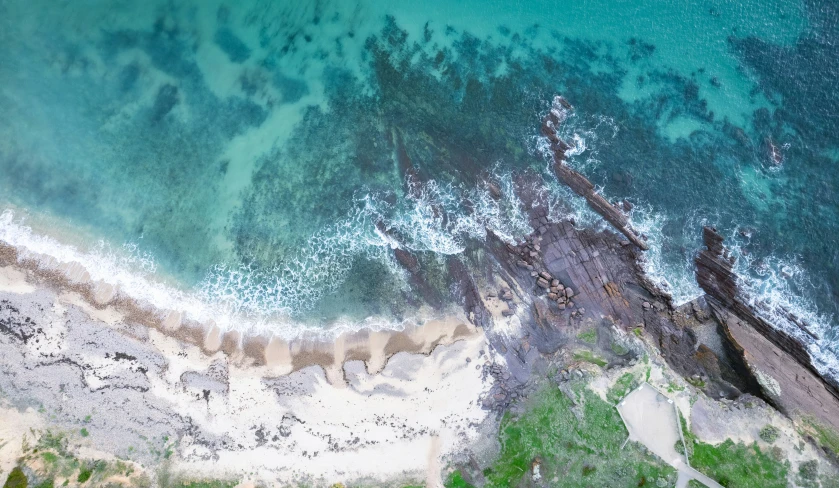 an aerial s of a beach with green water