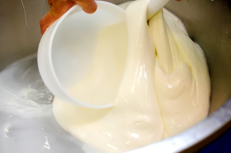 a bowl filled with white batter being poured