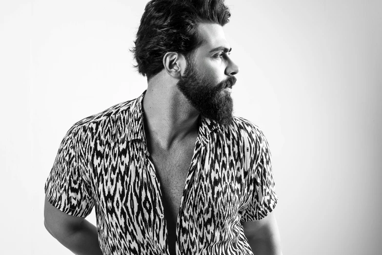 a man with a beard and an oversize shirt in a studio