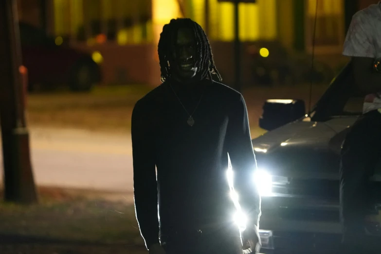 a man with long hair and dreadlocks wearing a black outfit