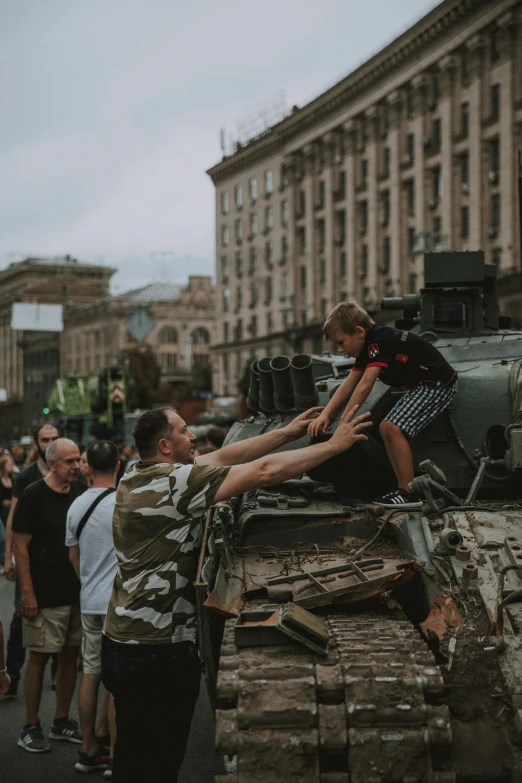 two young children ride on top of a tank