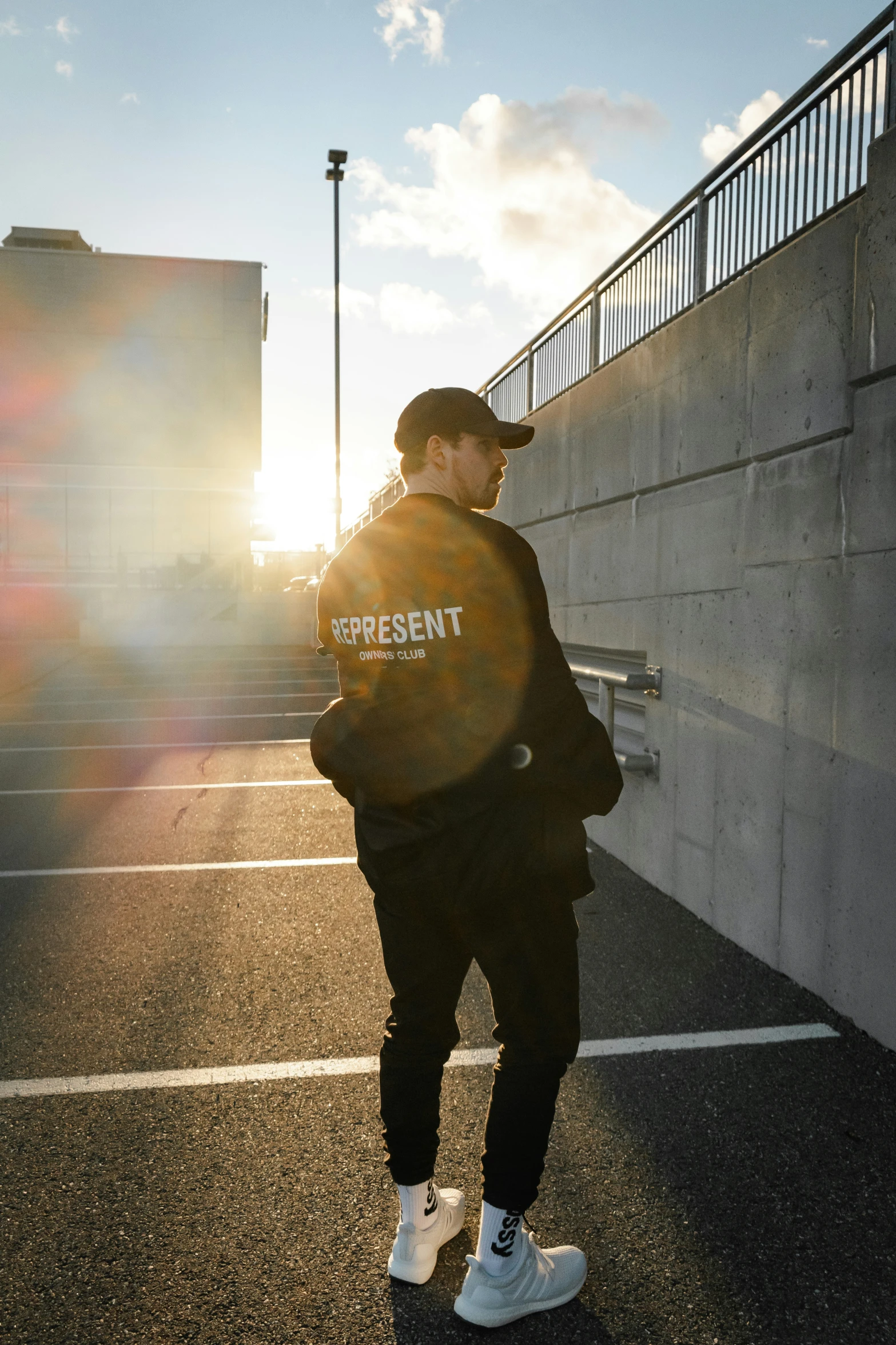 a man with a backpack standing on top of a parking lot