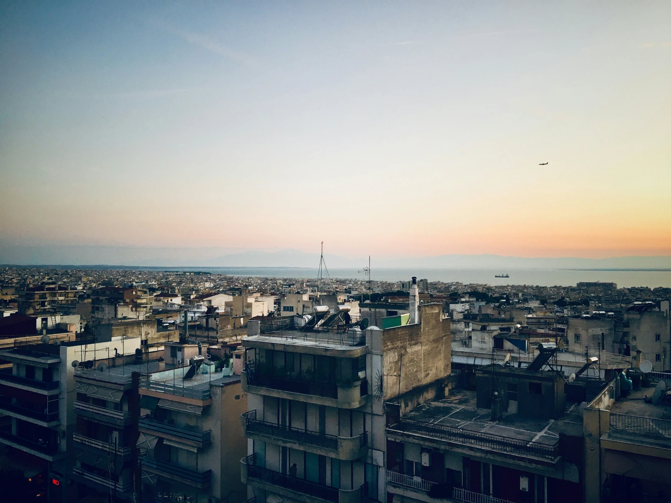 an evening view looking over some buildings and the ocean