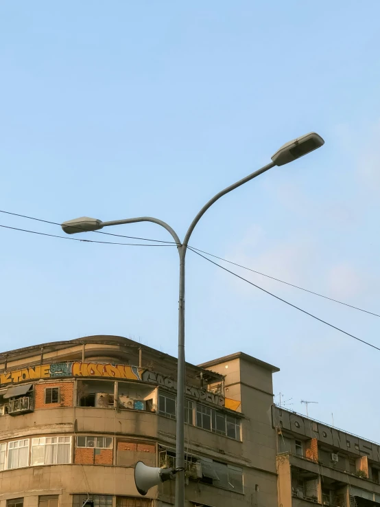 a tall lamp post next to an apartment building